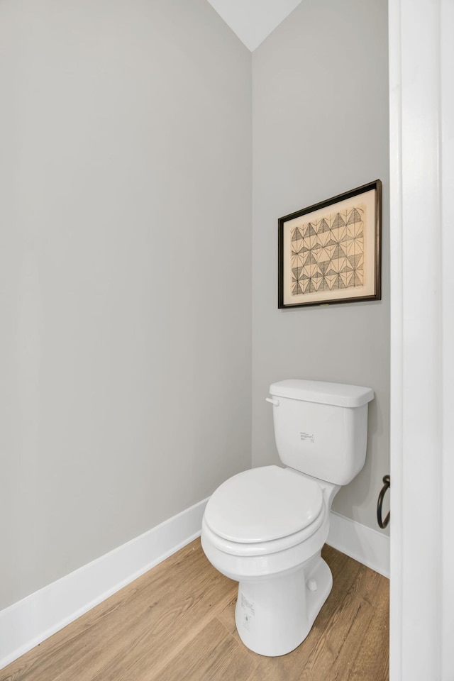 bathroom with toilet and hardwood / wood-style floors