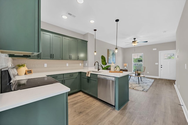 kitchen with sink, appliances with stainless steel finishes, kitchen peninsula, and green cabinets