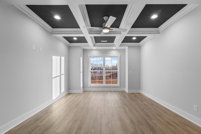 empty room featuring coffered ceiling, light wood-type flooring, ornamental molding, ceiling fan, and beamed ceiling