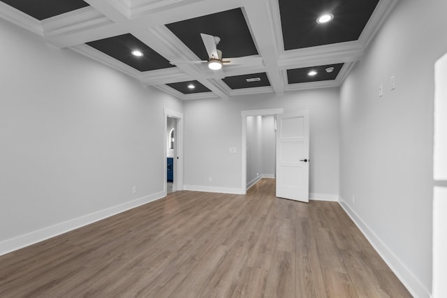 unfurnished room featuring light wood-type flooring, beam ceiling, ceiling fan, ornamental molding, and coffered ceiling