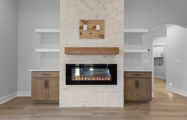 interior details with built in features, a fireplace, and wood-type flooring