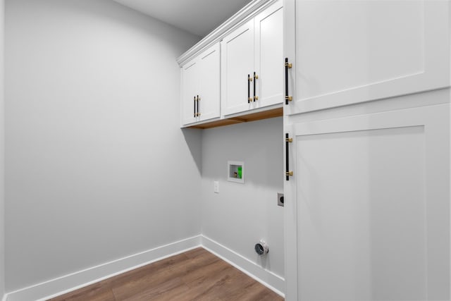 clothes washing area featuring hardwood / wood-style flooring, hookup for a washing machine, cabinets, and hookup for an electric dryer