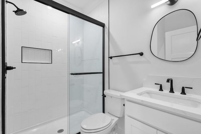 bathroom featuring toilet, a shower with door, and vanity