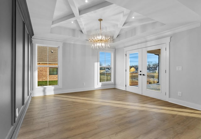 unfurnished room featuring coffered ceiling, hardwood / wood-style floors, a chandelier, french doors, and beam ceiling