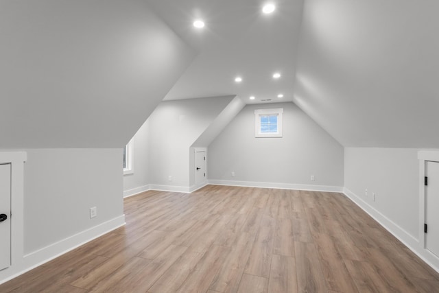 additional living space with vaulted ceiling, plenty of natural light, and light hardwood / wood-style floors