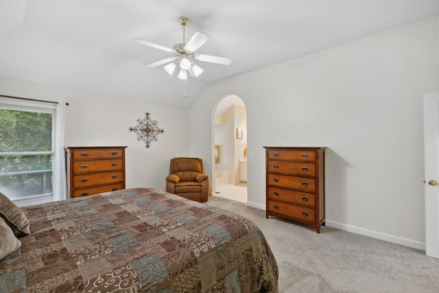 bedroom with connected bathroom, light carpet, ceiling fan, and vaulted ceiling