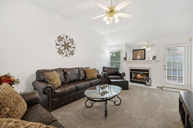 living room with a healthy amount of sunlight, light colored carpet, vaulted ceiling, and ceiling fan