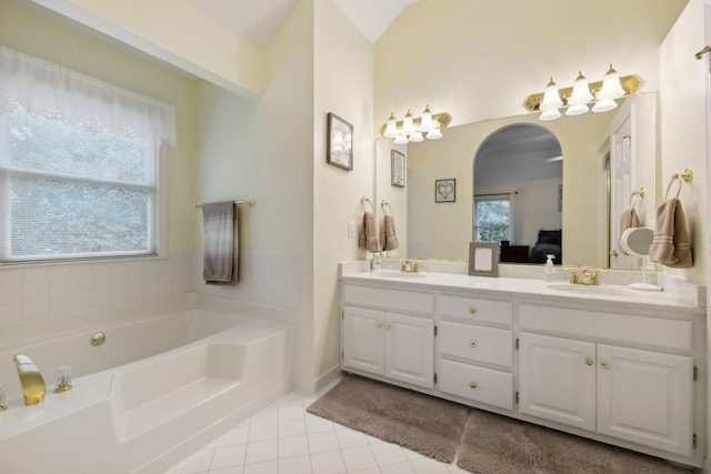 bathroom featuring lofted ceiling, tile patterned flooring, a bathtub, and vanity