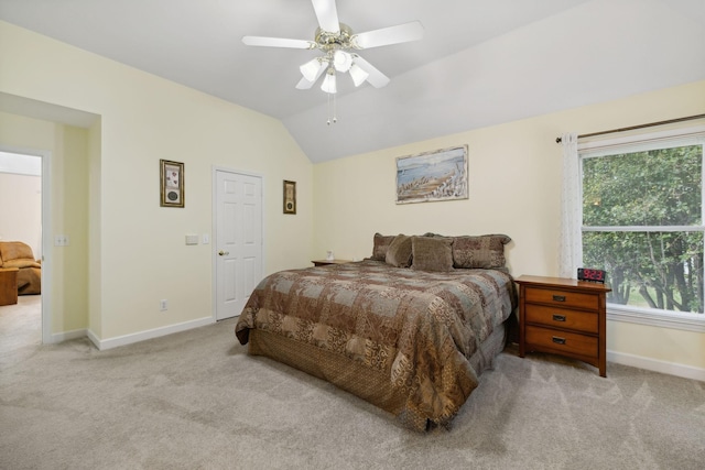 bedroom with ceiling fan, vaulted ceiling, and light carpet