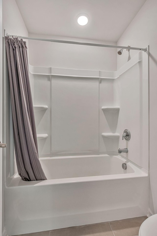 bathroom featuring tile patterned flooring, shower / bath combination with curtain, and toilet