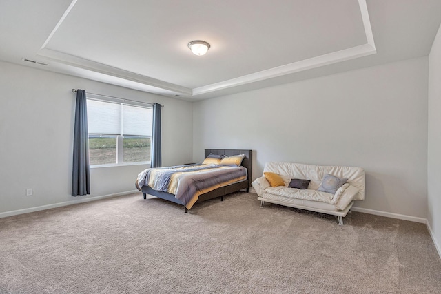 bedroom featuring a tray ceiling and carpet flooring