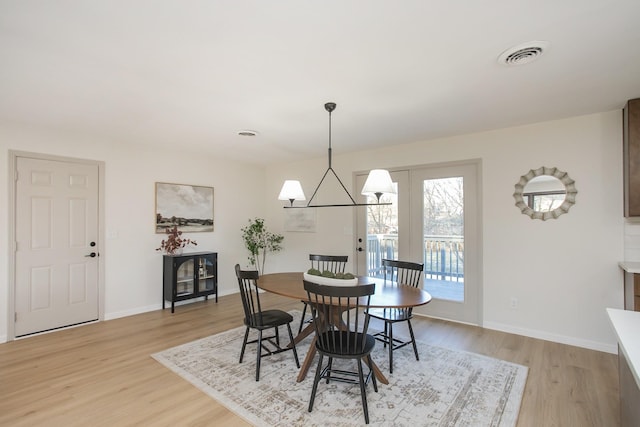 dining area featuring a chandelier and light wood-type flooring