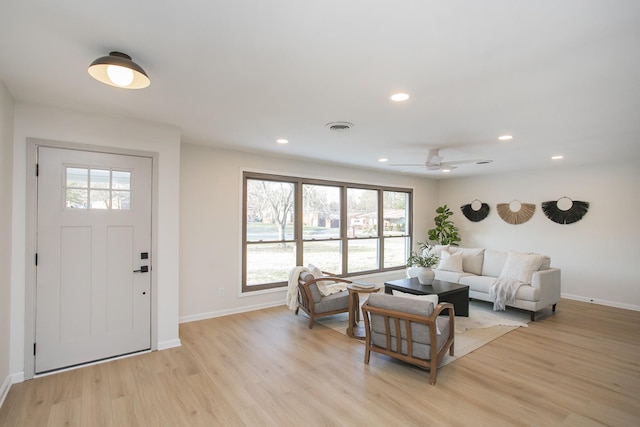 living room with ceiling fan and light hardwood / wood-style flooring