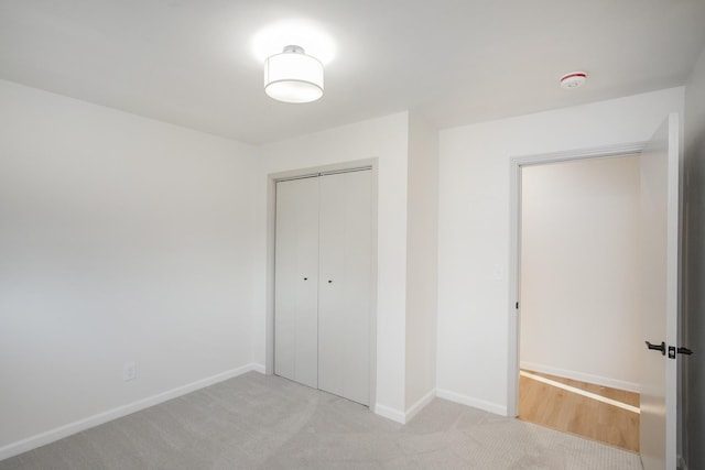 unfurnished bedroom featuring a closet and light carpet