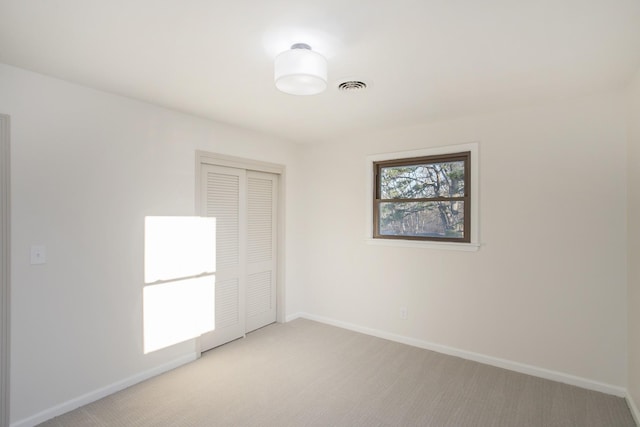 unfurnished room featuring light carpet