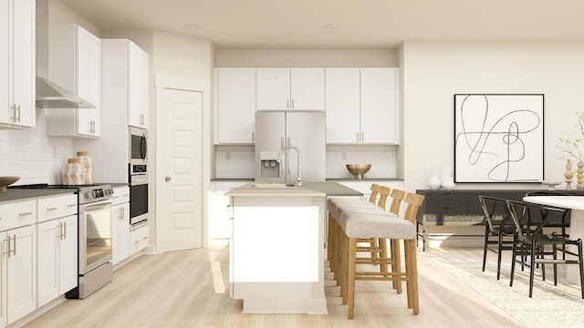 kitchen featuring stainless steel appliances, a breakfast bar, white cabinets, and a kitchen island with sink