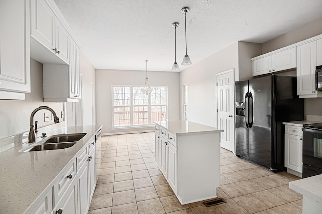 kitchen featuring sink, black fridge, white cabinetry, and electric range