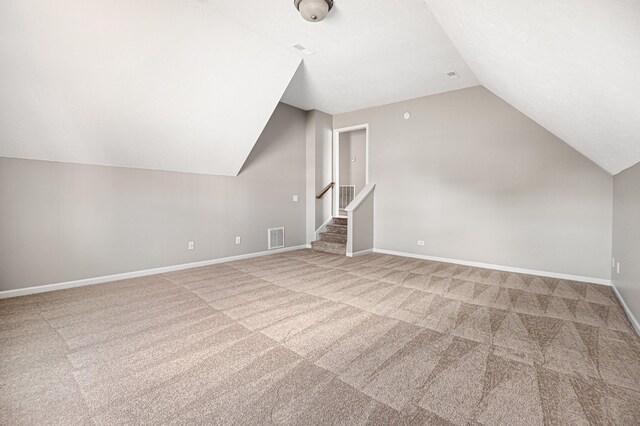 additional living space featuring lofted ceiling and carpet