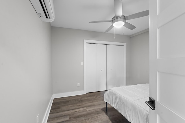 bedroom with dark hardwood / wood-style flooring, a closet, ceiling fan, and a wall mounted air conditioner