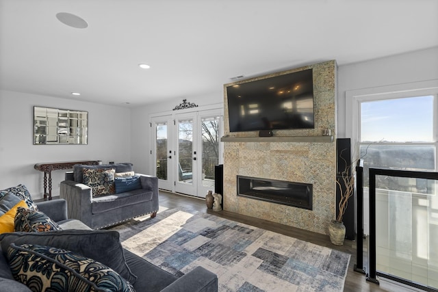 living room with a tile fireplace, french doors, and dark hardwood / wood-style flooring