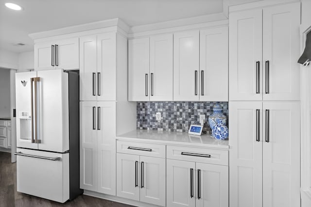 kitchen with high end white refrigerator, white cabinets, decorative backsplash, and dark hardwood / wood-style floors