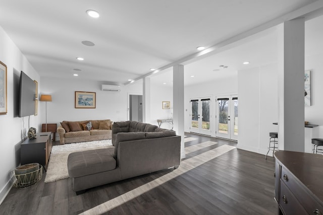 living room featuring an AC wall unit and dark hardwood / wood-style floors