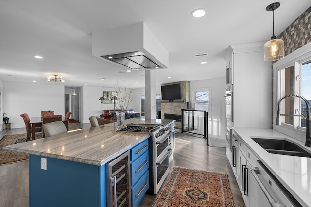 kitchen featuring double oven range, wine cooler, white cabinetry, blue cabinets, and sink