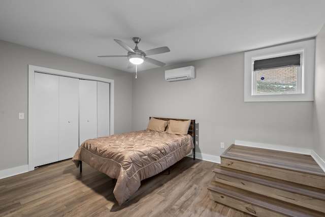 bedroom with wood-type flooring, an AC wall unit, a closet, and ceiling fan