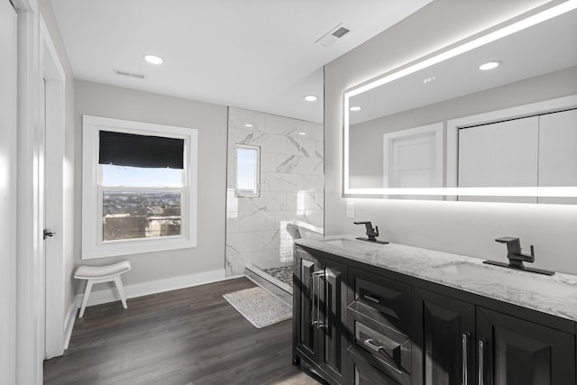 bathroom featuring tiled shower, wood-type flooring, and vanity