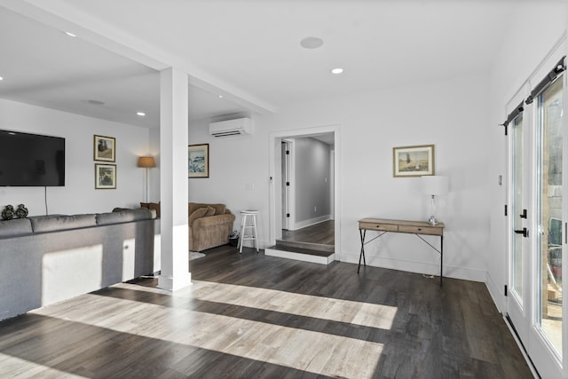 entrance foyer with dark hardwood / wood-style flooring, a wealth of natural light, and a wall unit AC