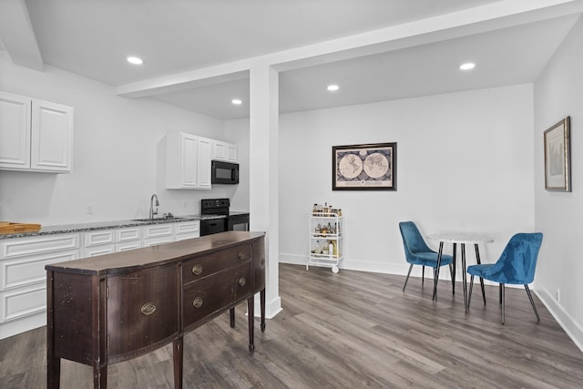 kitchen with white cabinets, beam ceiling, black appliances, and sink