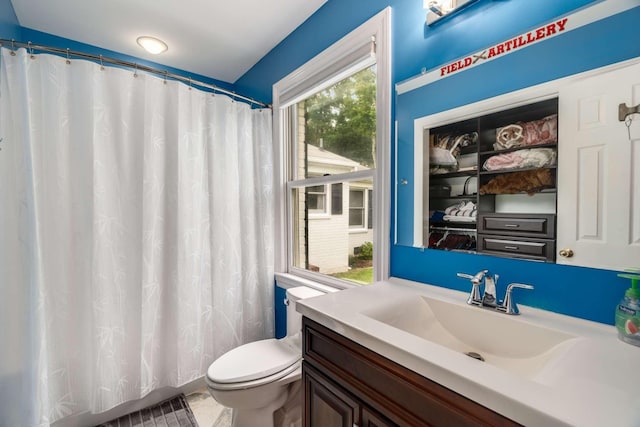 bathroom with a shower with curtain, tile patterned flooring, vanity, and toilet