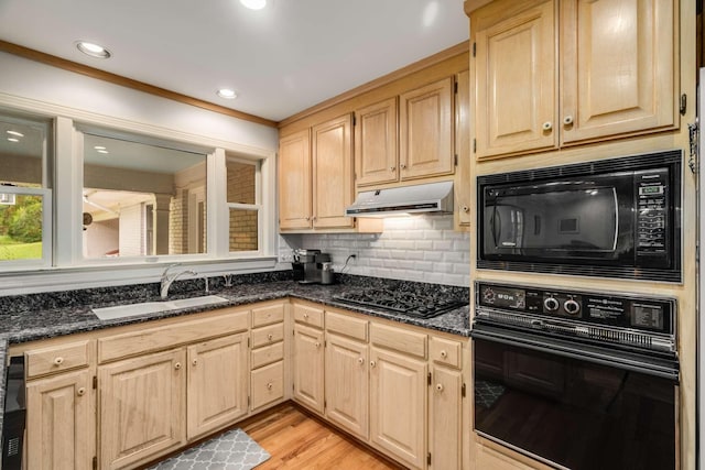 kitchen featuring sink, light brown cabinetry, dark stone countertops, and black appliances