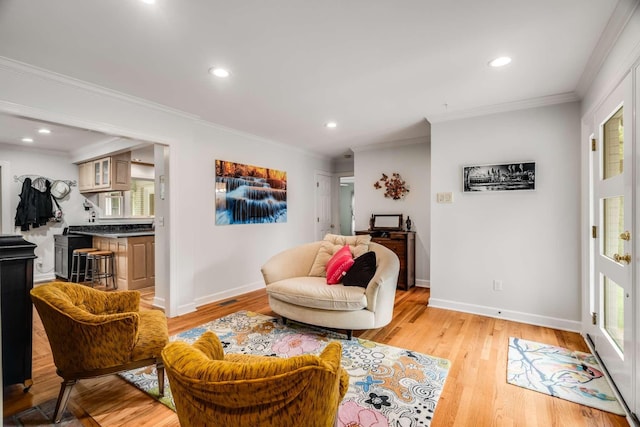 living area featuring light hardwood / wood-style floors and crown molding