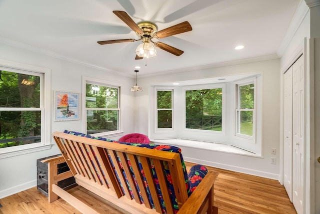 bedroom with multiple windows, a closet, ceiling fan, and ornamental molding