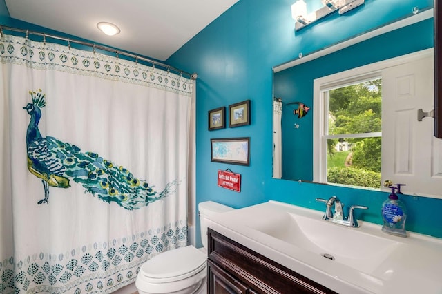 bathroom featuring a shower with shower curtain, vanity, and toilet