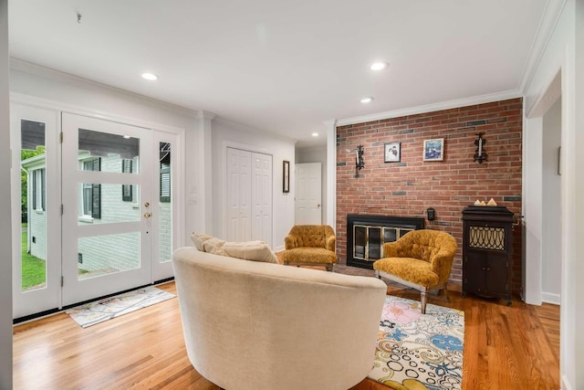 living room featuring a fireplace, light wood-type flooring, and crown molding