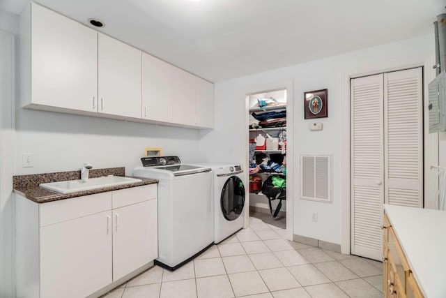 laundry area with sink, light tile patterned flooring, washer and dryer, and cabinets