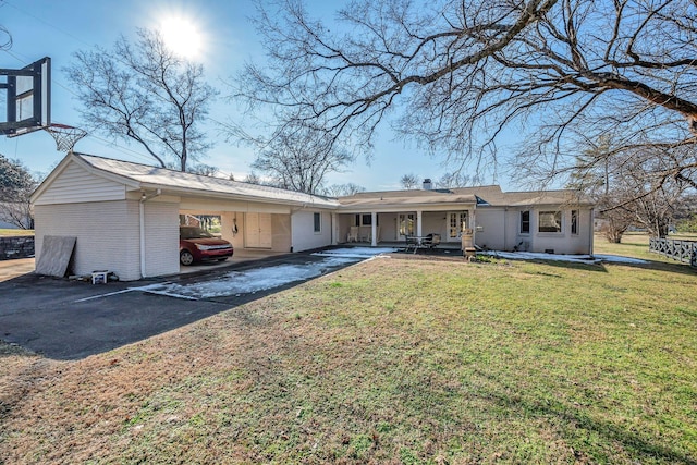 rear view of house featuring a carport and a lawn