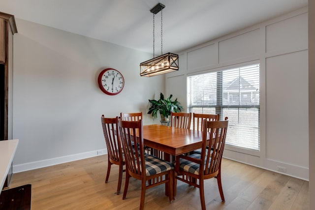 dining room with light hardwood / wood-style floors and a notable chandelier