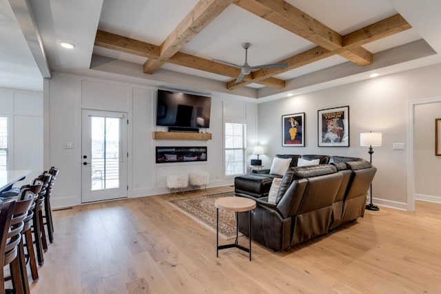 living room featuring light hardwood / wood-style floors, ceiling fan, beamed ceiling, and coffered ceiling