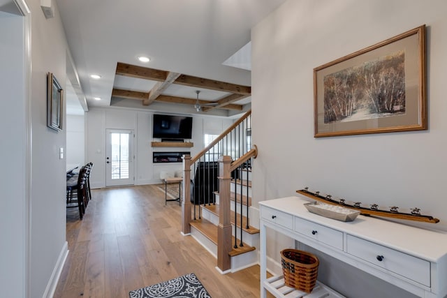 foyer with ceiling fan, light hardwood / wood-style flooring, beam ceiling, and coffered ceiling