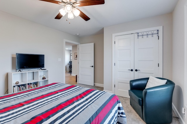 bedroom with ceiling fan, a closet, and light carpet