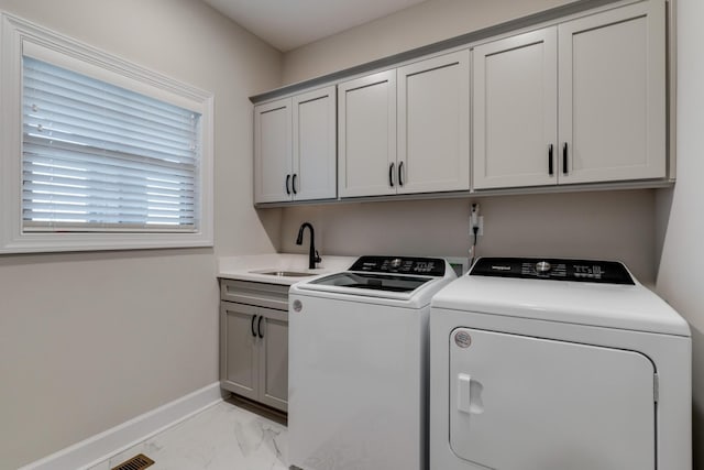 washroom featuring cabinets, washing machine and clothes dryer, and sink