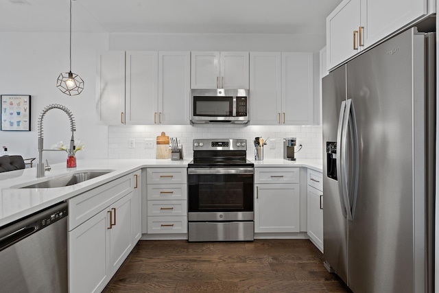 kitchen with sink, white cabinets, pendant lighting, and appliances with stainless steel finishes