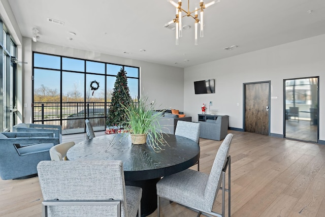 dining space featuring light hardwood / wood-style flooring and a chandelier