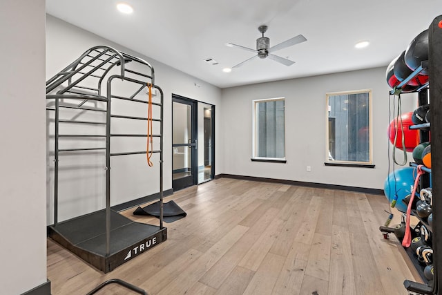 workout room with ceiling fan and light hardwood / wood-style flooring