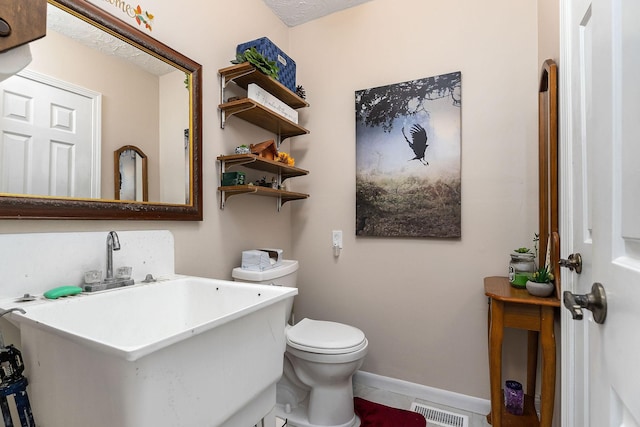 bathroom with sink, tile patterned flooring, a textured ceiling, and toilet