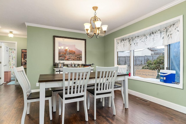 dining space with an inviting chandelier, crown molding, and dark hardwood / wood-style flooring