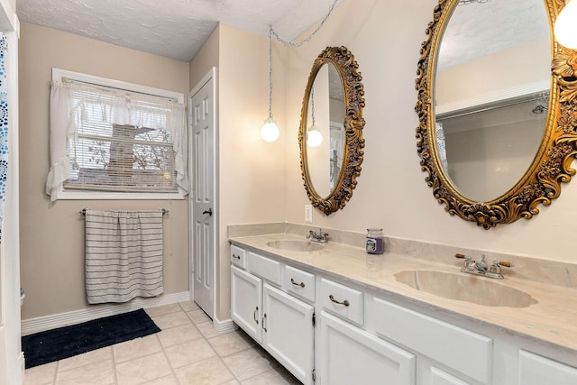 bathroom featuring a textured ceiling, tile patterned floors, and vanity